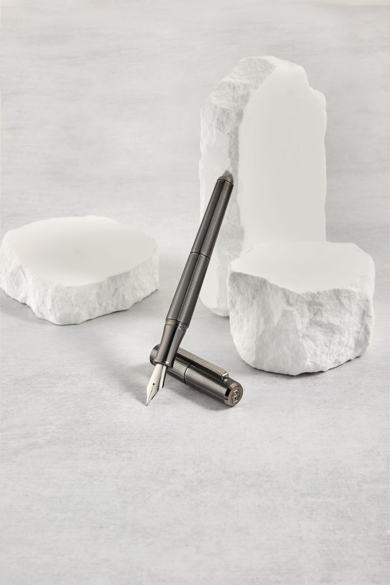 A writing instrument resting on white stone — Hugo Boss